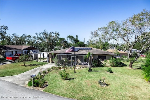 ranch-style home featuring a front yard, solar panels, and a sunroom