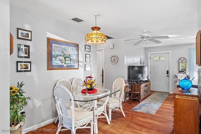 dining space with ceiling fan and wood-type flooring