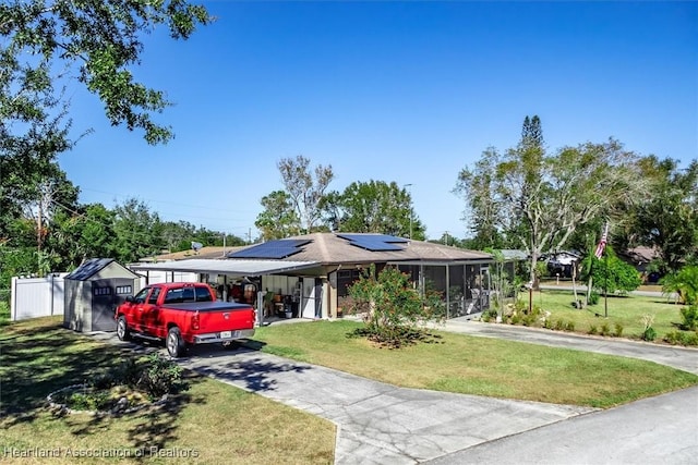 view of front of property with a front yard, solar panels, and a sunroom