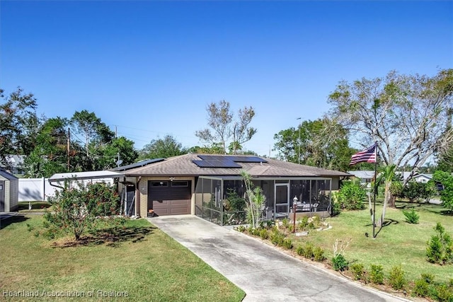 single story home with a sunroom, a front lawn, a garage, and solar panels