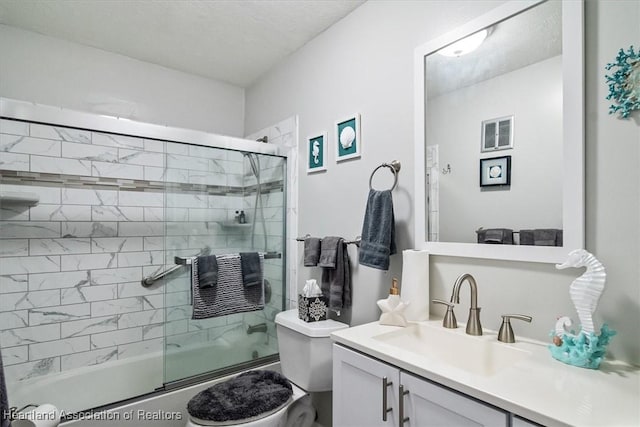 full bathroom featuring combined bath / shower with glass door, vanity, and toilet