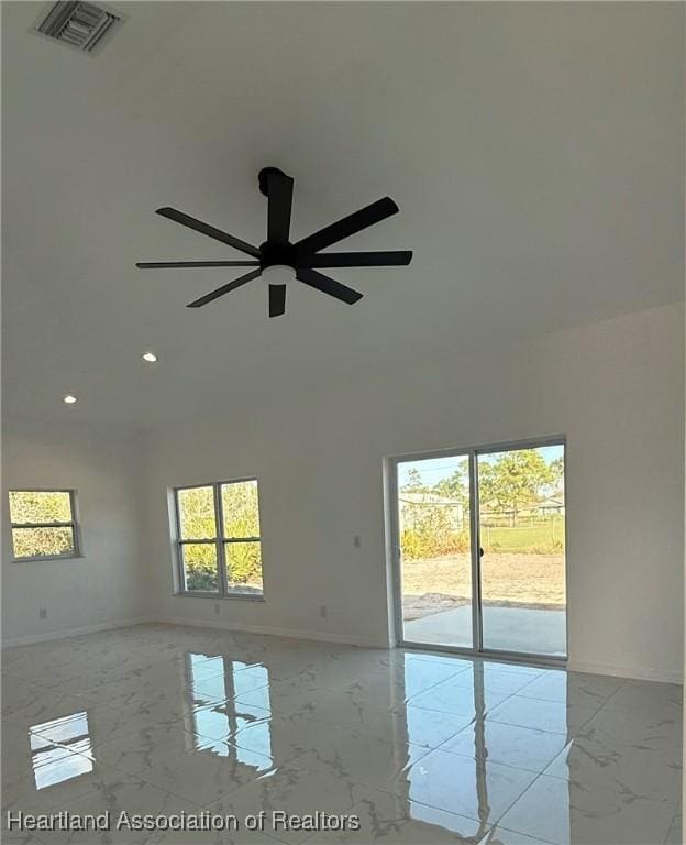 empty room with ceiling fan and a wealth of natural light