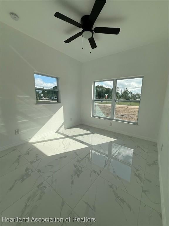 unfurnished room featuring a wealth of natural light and ceiling fan