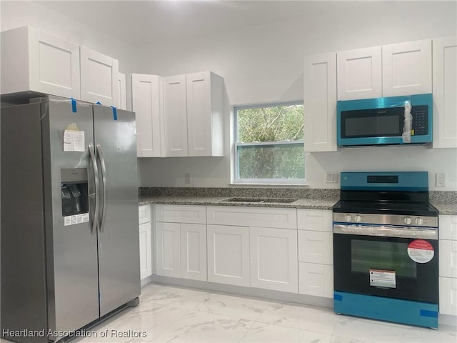 kitchen featuring white cabinetry and appliances with stainless steel finishes