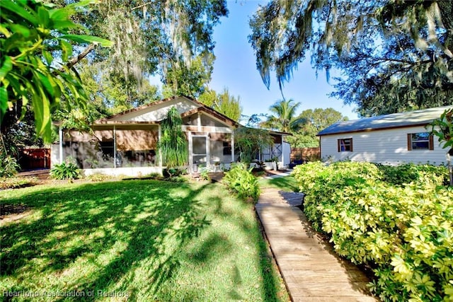 exterior space featuring a front lawn and a sunroom