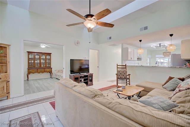 tiled living room with high vaulted ceiling and ceiling fan