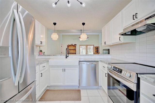 kitchen with sink, light tile patterned flooring, decorative light fixtures, white cabinets, and appliances with stainless steel finishes