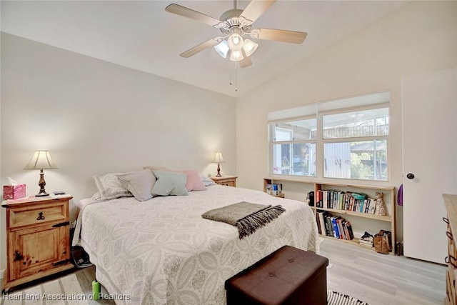 bedroom featuring ceiling fan, light hardwood / wood-style floors, and vaulted ceiling