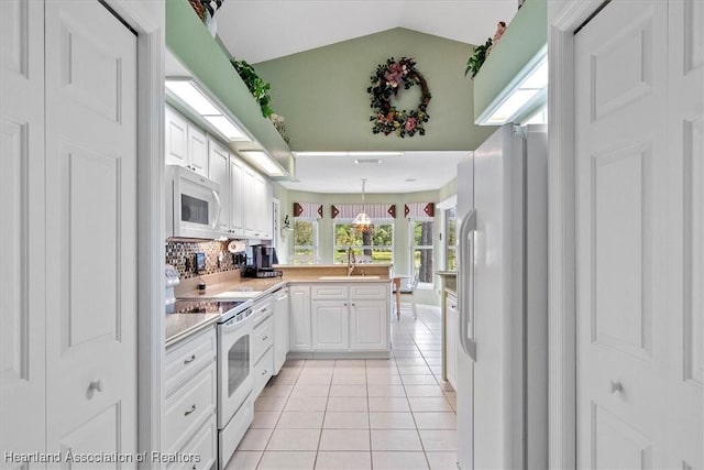 kitchen with white cabinetry, white appliances, decorative light fixtures, and light tile patterned floors