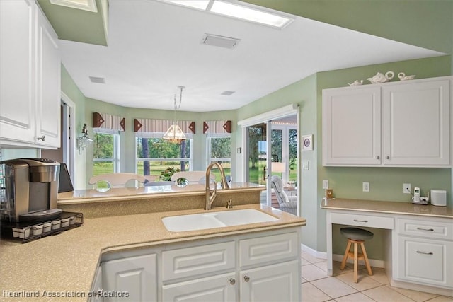 kitchen featuring white cabinetry, sink, pendant lighting, and light tile patterned floors