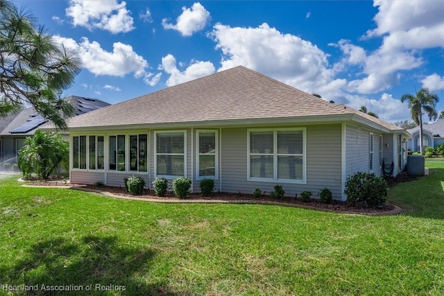 back of house featuring central AC and a lawn