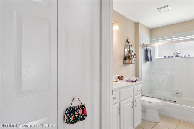 full bathroom featuring vanity, tile patterned floors, enclosed tub / shower combo, and toilet