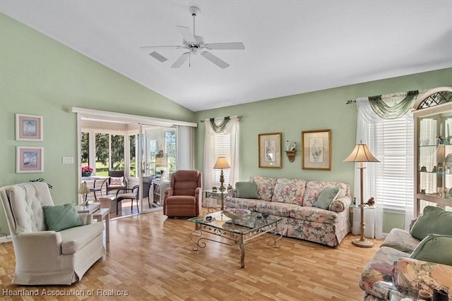 living room with ceiling fan, lofted ceiling, and light hardwood / wood-style floors