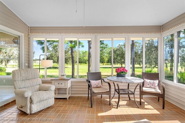 sunroom with lofted ceiling and a healthy amount of sunlight