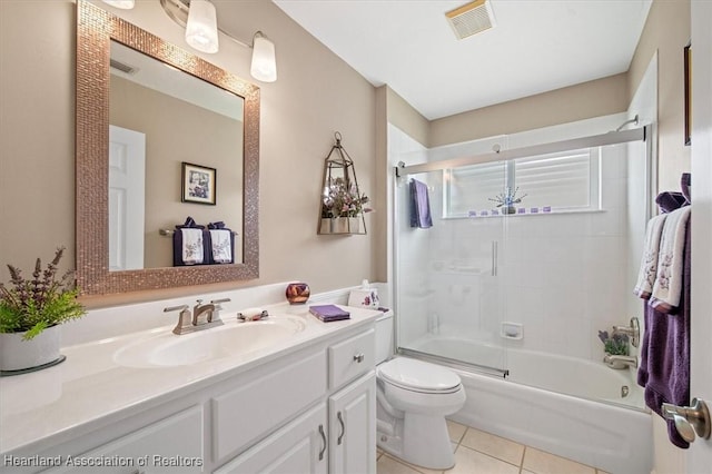 full bathroom with bath / shower combo with glass door, tile patterned floors, toilet, and vanity