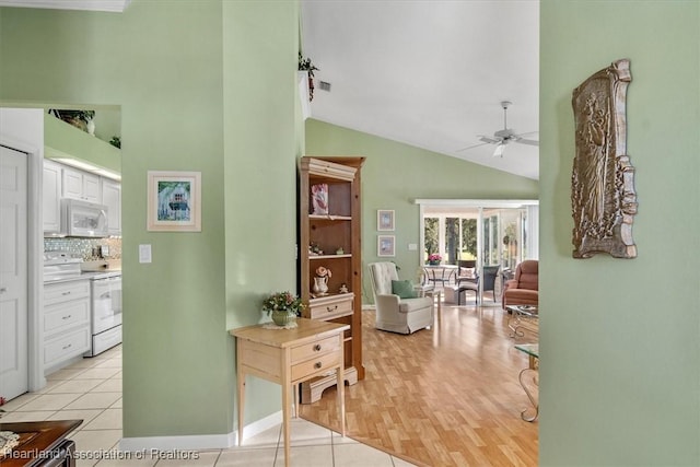 hallway with lofted ceiling and light tile patterned floors