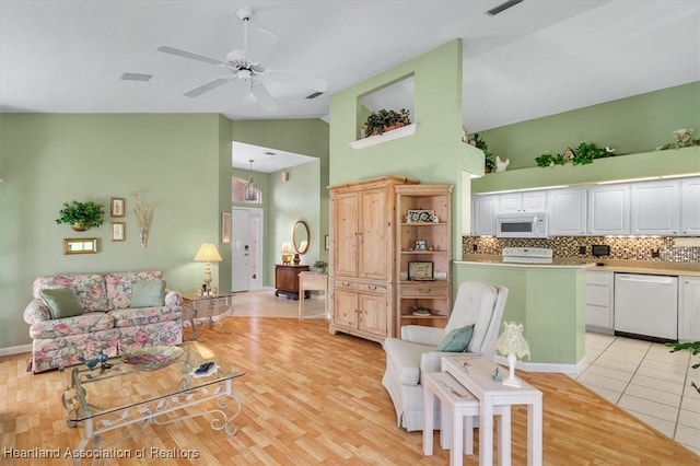 tiled living room featuring high vaulted ceiling and ceiling fan