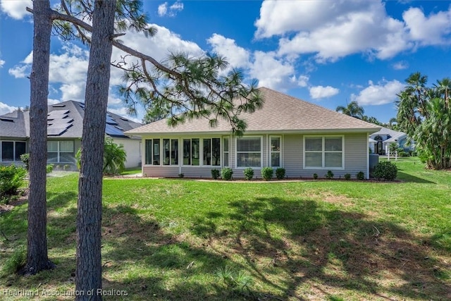 view of front of house with a sunroom and a front lawn