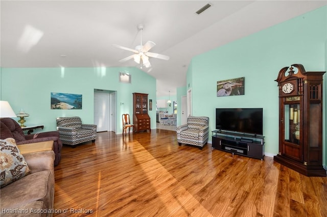 living area featuring vaulted ceiling, a ceiling fan, wood finished floors, and visible vents