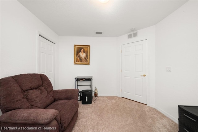 living area with light carpet, visible vents, and baseboards