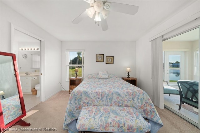 carpeted bedroom with a ceiling fan and ensuite bath