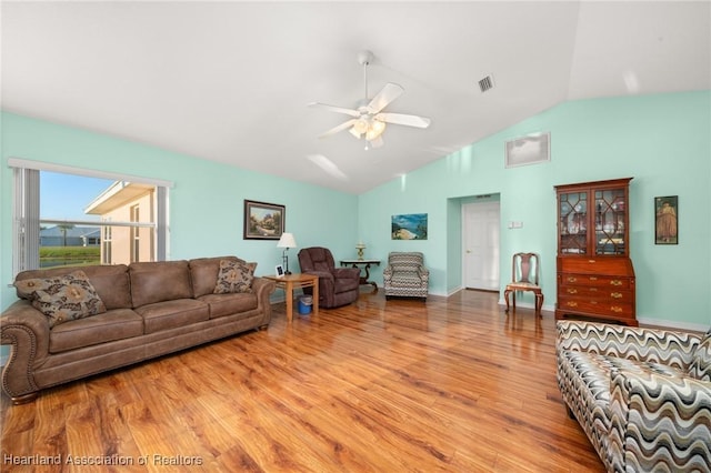 living room featuring wood finished floors, visible vents, lofted ceiling, and ceiling fan