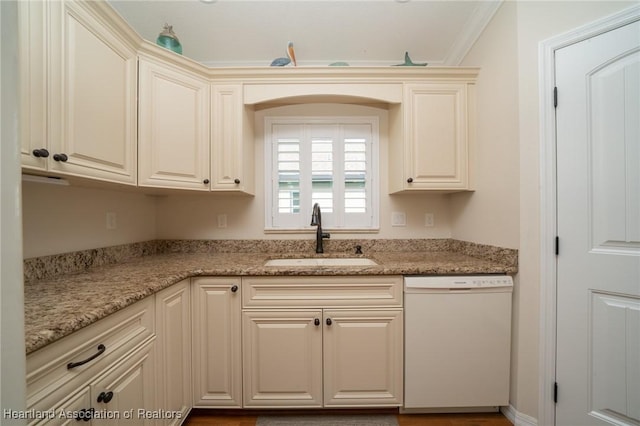 kitchen with dishwasher, sink, light stone countertops, and cream cabinetry