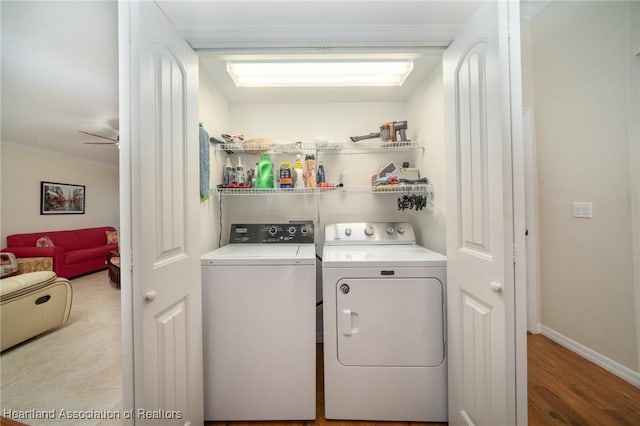 laundry area featuring ceiling fan, washing machine and clothes dryer, crown molding, and light hardwood / wood-style floors