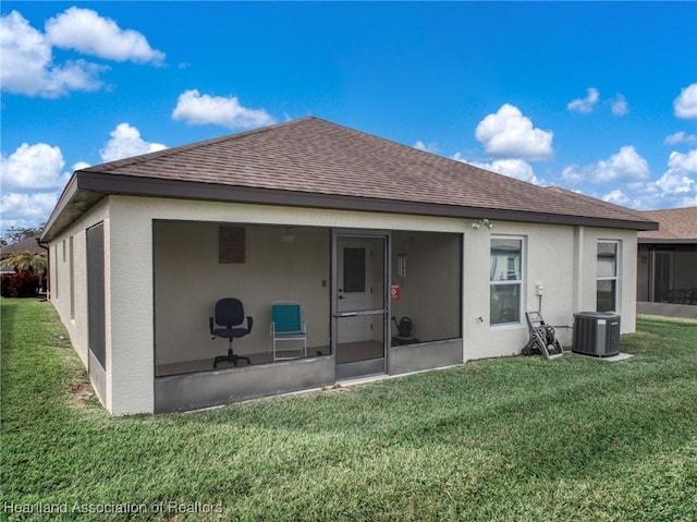 back of house featuring a sunroom, central AC unit, and a lawn