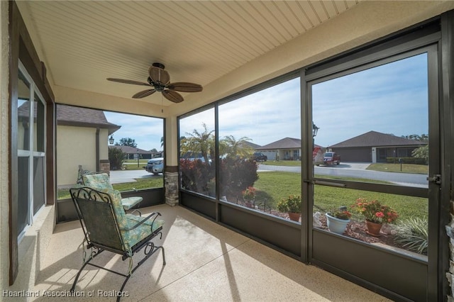 sunroom / solarium featuring a healthy amount of sunlight and ceiling fan