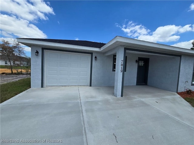 view of front of property featuring stucco siding, a garage, and concrete driveway