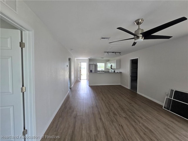 unfurnished living room featuring dark wood-style floors, baseboards, a ceiling fan, and visible vents