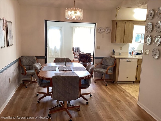 dining room with light hardwood / wood-style flooring and an inviting chandelier