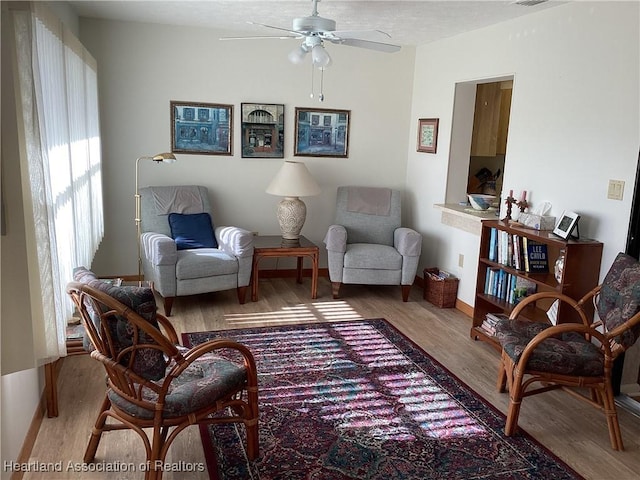 living area featuring ceiling fan and hardwood / wood-style flooring