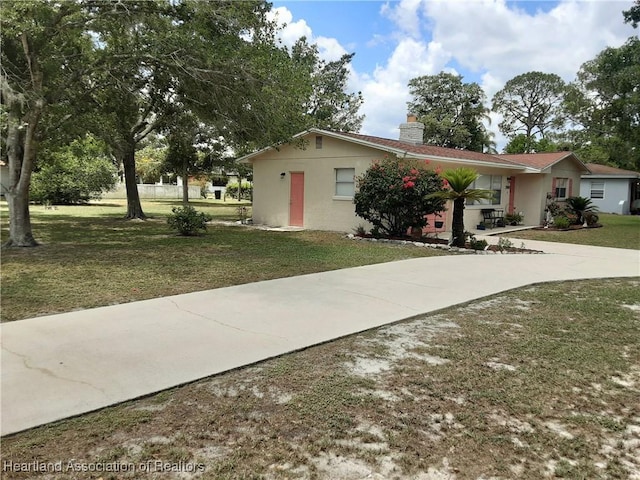 200 Robin Ave, Sebring, FL 33870 - view of front facade with a chimney, a front yard, concrete driveway, and stucco siding