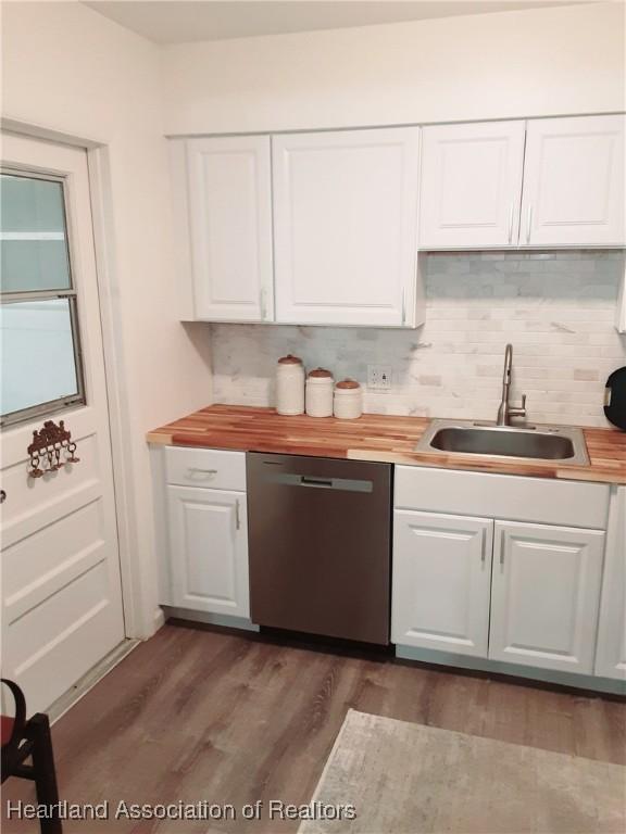 200 Robin Ave, Sebring, FL 33870 - kitchen with stainless steel dishwasher, a sink, white cabinetry, wood finished floors, and backsplash