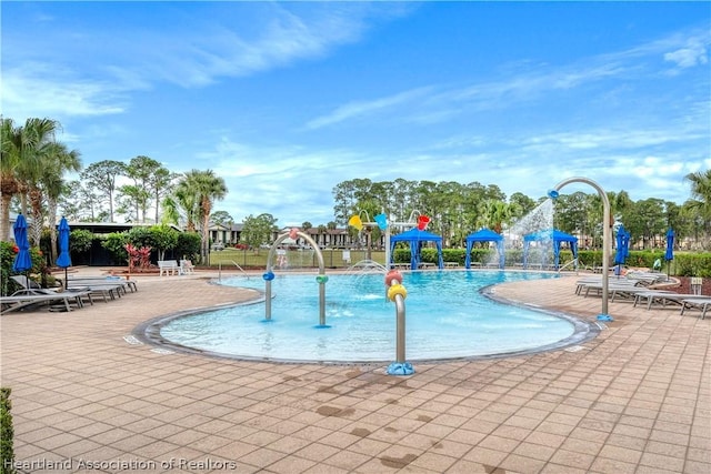 view of pool with pool water feature and a patio