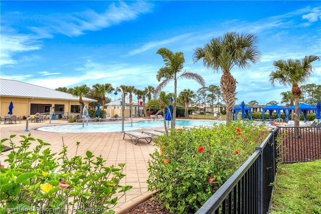 view of swimming pool with pool water feature and a patio