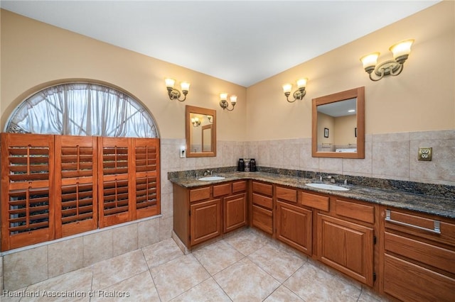 bathroom featuring tile patterned flooring, vanity, and tasteful backsplash