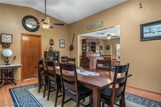 dining space featuring ceiling fan, vaulted ceiling, and hardwood / wood-style flooring