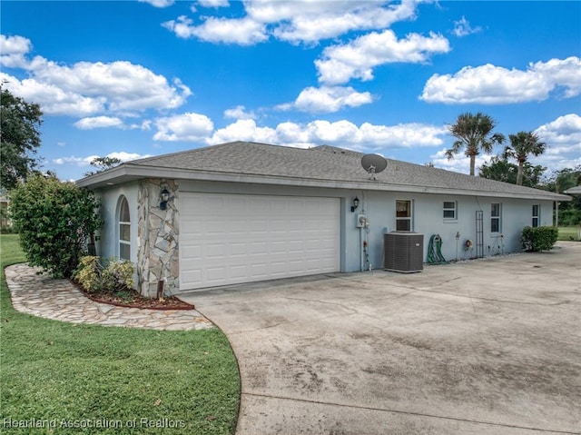 view of front of home with a front yard, a garage, and central air condition unit