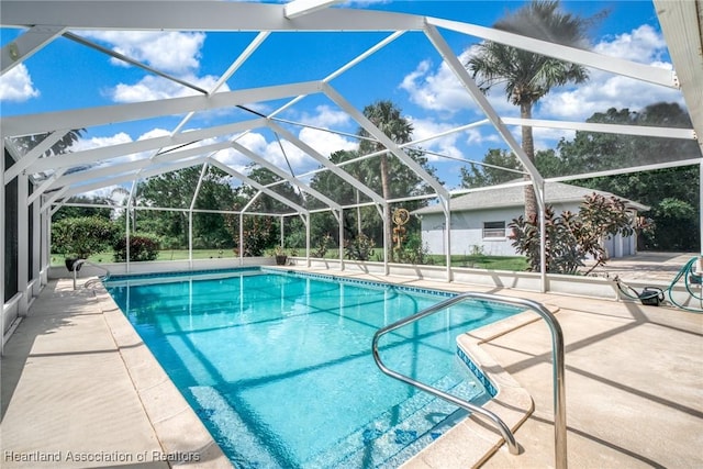 view of pool with glass enclosure and a patio area