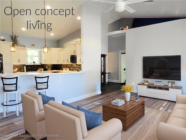 living room with ceiling fan, high vaulted ceiling, and light wood-type flooring