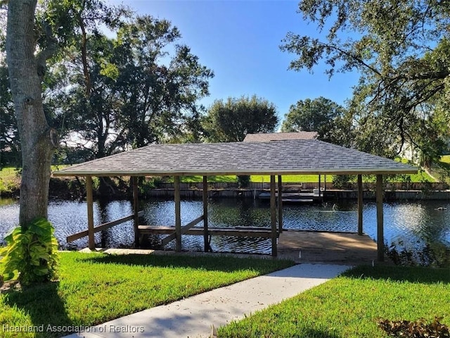 view of dock featuring a lawn and a water view