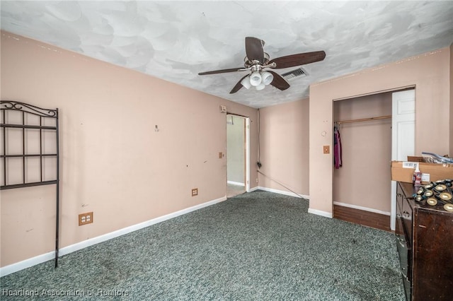 unfurnished bedroom with ceiling fan, dark carpet, a textured ceiling, and a closet