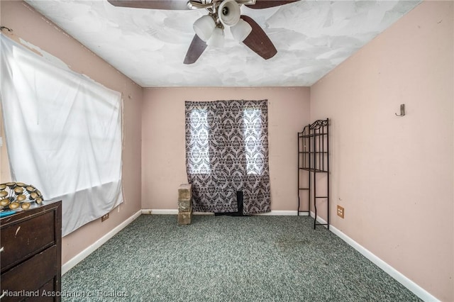 carpeted spare room featuring ceiling fan