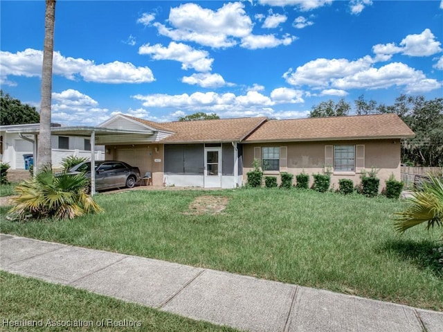 ranch-style house featuring a front yard and a carport