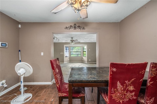 dining area with wood-type flooring and ceiling fan