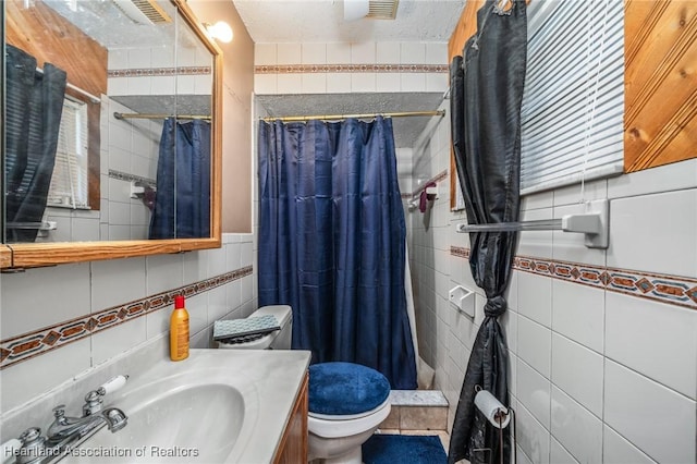 bathroom featuring curtained shower, vanity, tile walls, and toilet