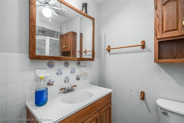 bathroom featuring a textured ceiling, toilet, decorative backsplash, vanity, and tile walls